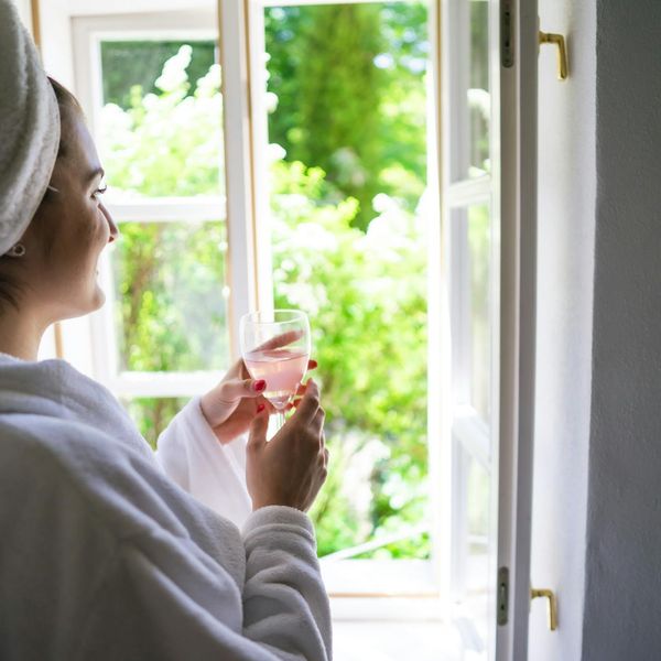 A person smiling peacefully after a workout, looking out a window.