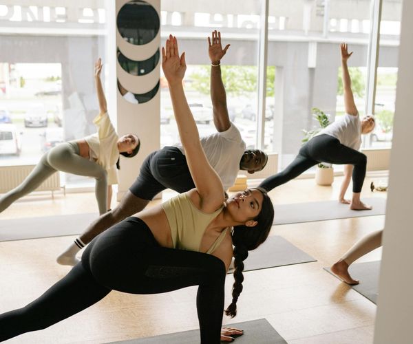 Group of diverse people in a circle during a cool-down phase of a fitness class.